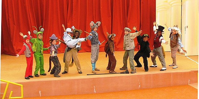 Children on stage dressed as animals.