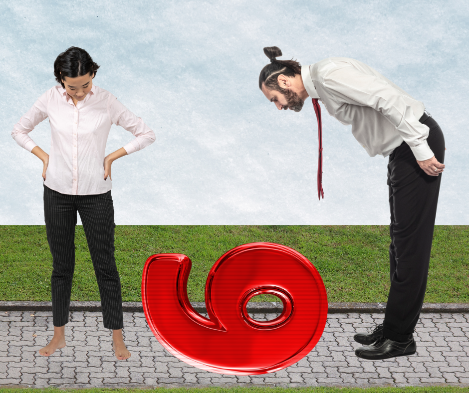 A woman and a man observe a large red metallic sculpture shaped like a sideways "9" on a paved path.