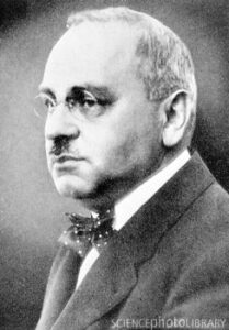 Black and white portrait of older man wearing spectacles and a bow tie