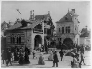 Street scene with people walking in front of two ornate historical buildings.