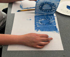 Person doing printmaking with a blue flower design.