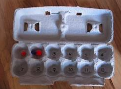 Egg carton with numbers and pompoms