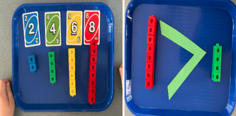 Two blue trays: left shows Uno cards and matching color blocks; right shows blocks and a "greater than" symbol.