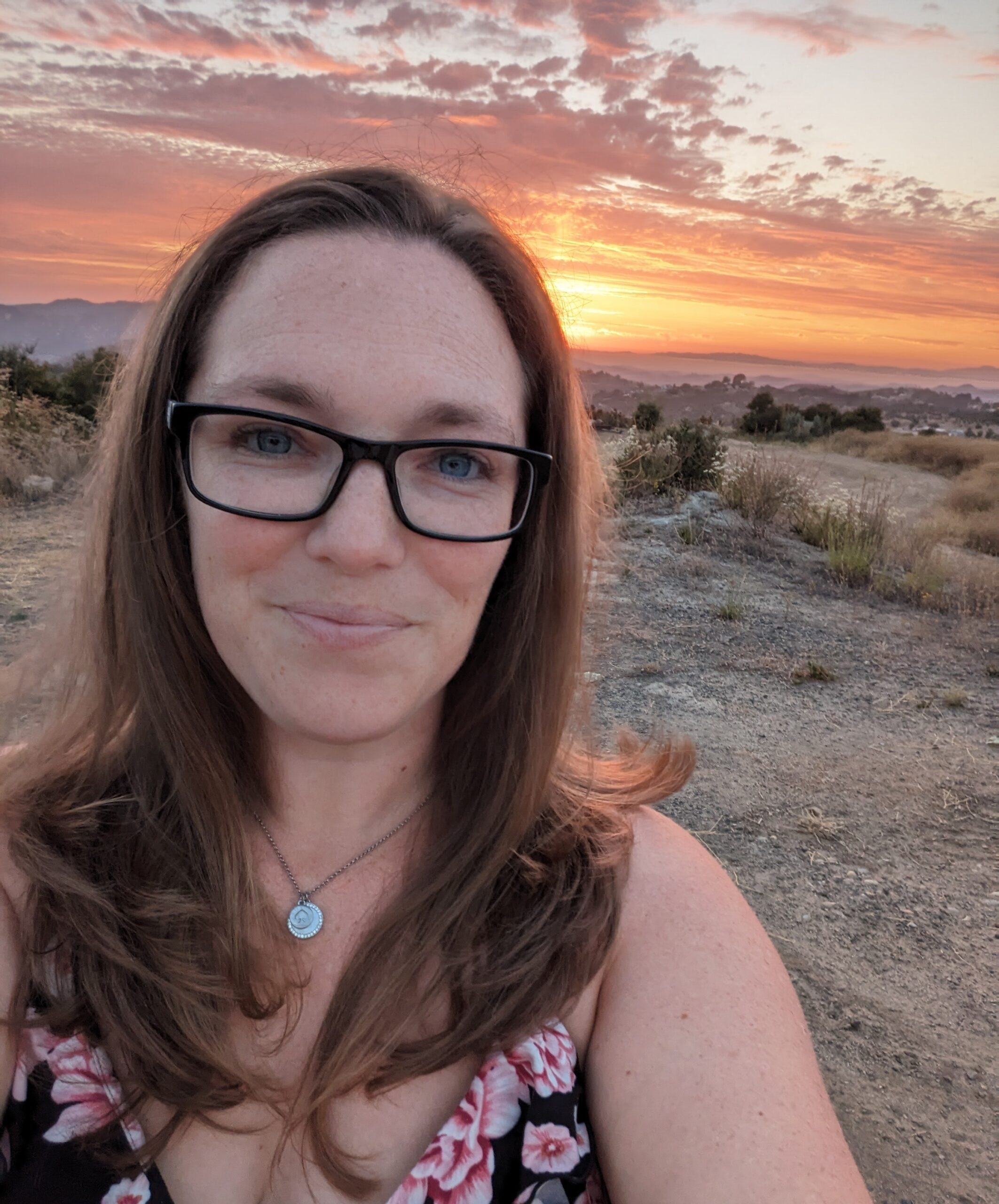 woman with long brown hair smiling in the desert