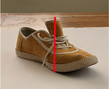 Photograph showing a single brown sneaker with a red vertical line demonstrating height measurement dividing it into two halves. Left half displays the shoe in normal condition, while right half shows the shoe with an extended tongue and laces tied differently
