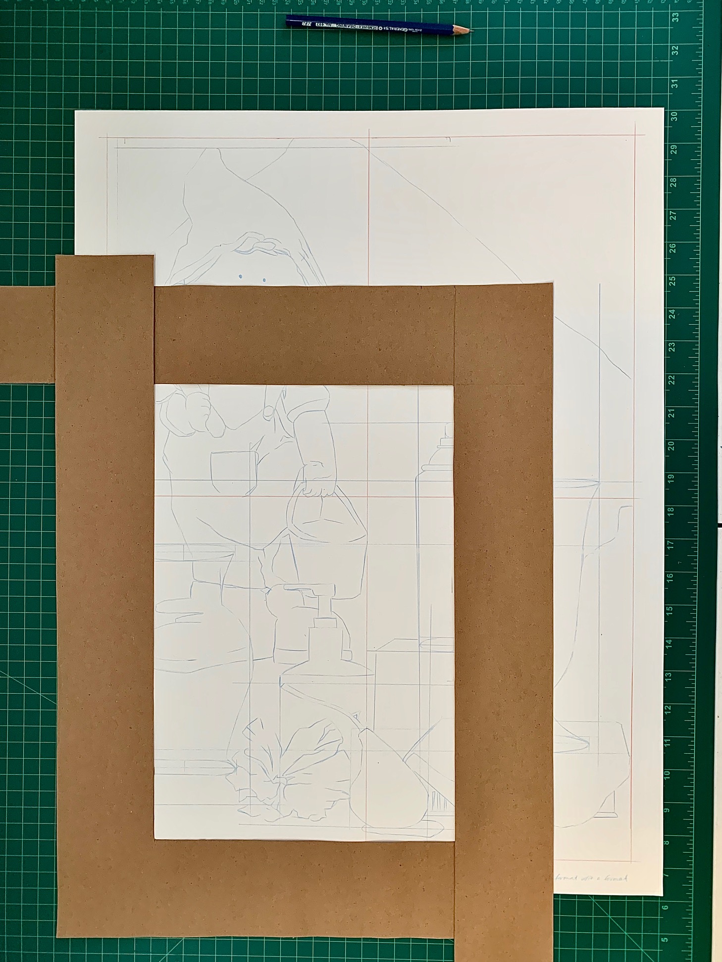 Photograph of a drawing setup featuring a large white paper with a grid and faint pencil sketch of a person holding an object, placed on a green cutting mat with measurement markings. Two brown cardboard L-shaped rulers frame the central portion of the paper, and a blue pencil rests above the paper, indicating preparation for detailed drawing work.