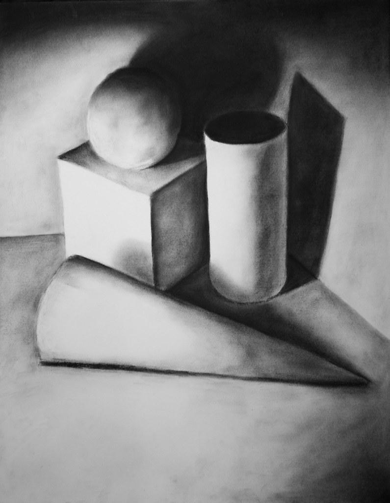 Black and white charcoal drawing of basic geometric shapes including a sphere, cube, cylinder, and cone arranged on a flat surface with strong light casting distinct shadows. The composition emphasizes shading and light contrast to create depth and three-dimensionality.