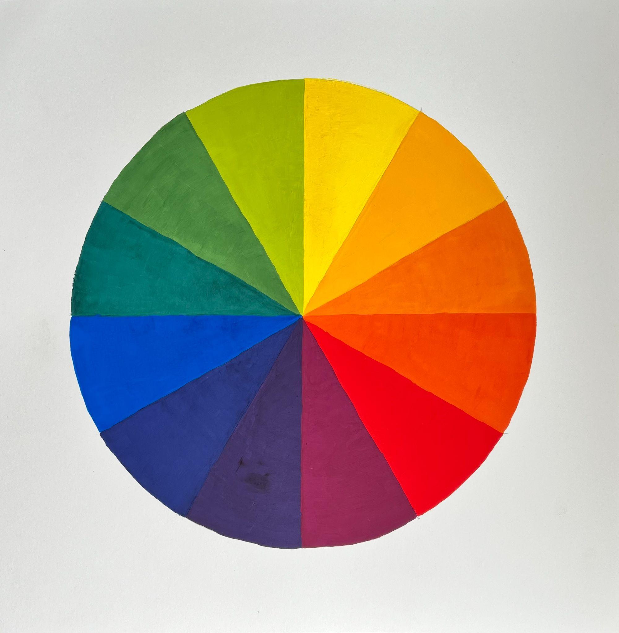 Color wheel diagram displaying twelve evenly divided segments in a circular layout, each segment painted in a distinct hue ranging from yellow, orange, red, purple, blue, to green. The diagram illustrates color relationships and transitions, useful for understanding color theory and harmony.
