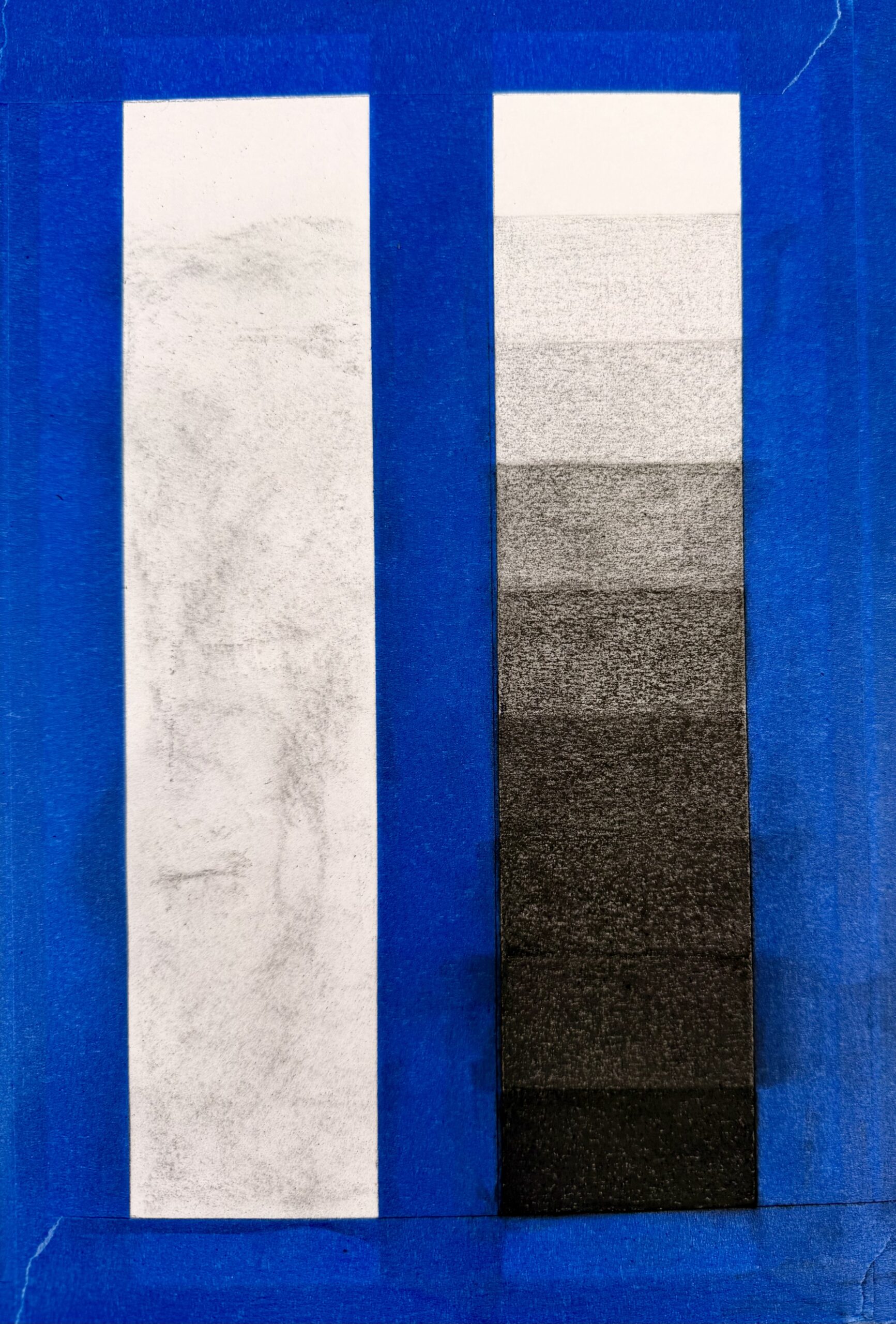 Photograph of two rectangular strips side by side on a blue background, with the top strip showing a faint, uneven gray texture and the bottom strip displaying six vertical value gradations from black to white.