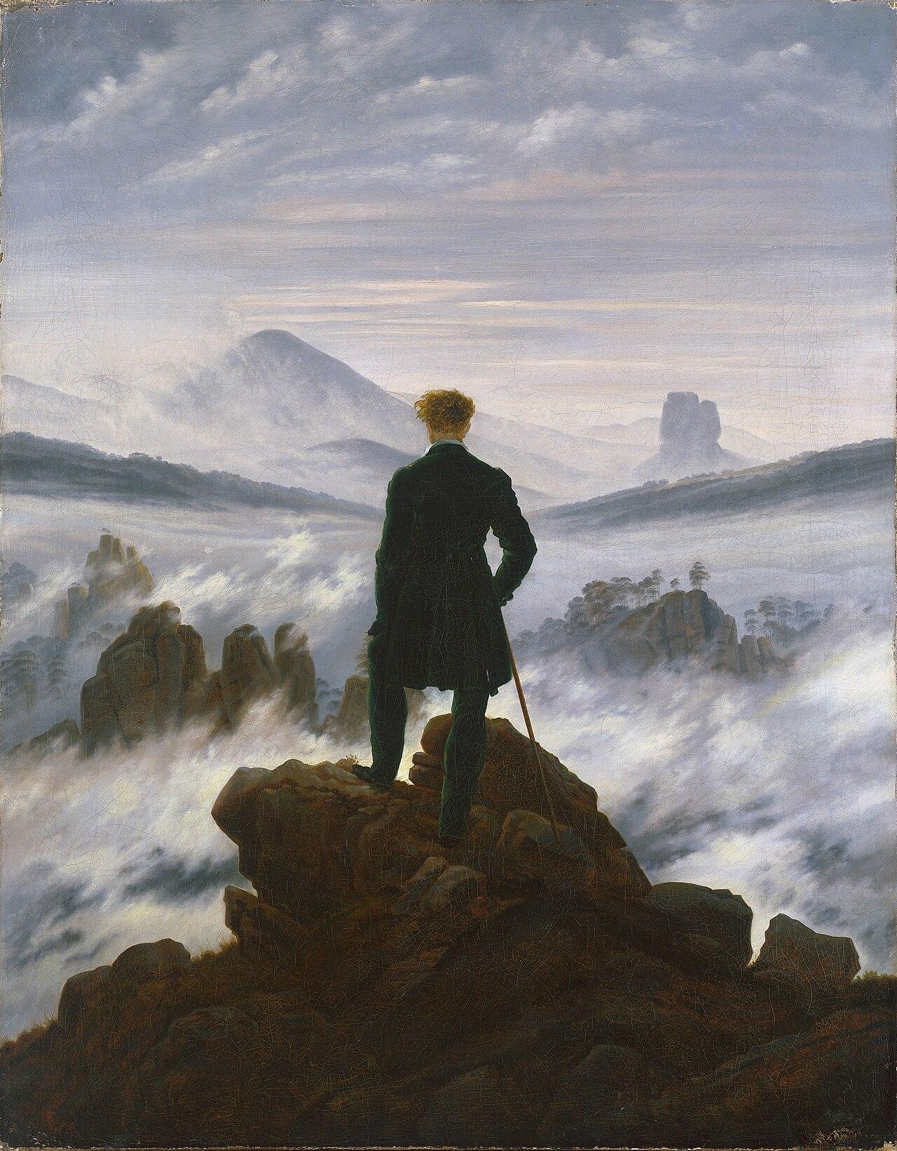 Romantic-style painting depicting a solitary man standing on rocky peak overlooking a vast, mist-covered mountainous landscape. The figure, dressed in dark clothing and holding a walking stick, faces away from viewer, emphasizing themes of exploration and contemplation amid dramatic natural scenery.