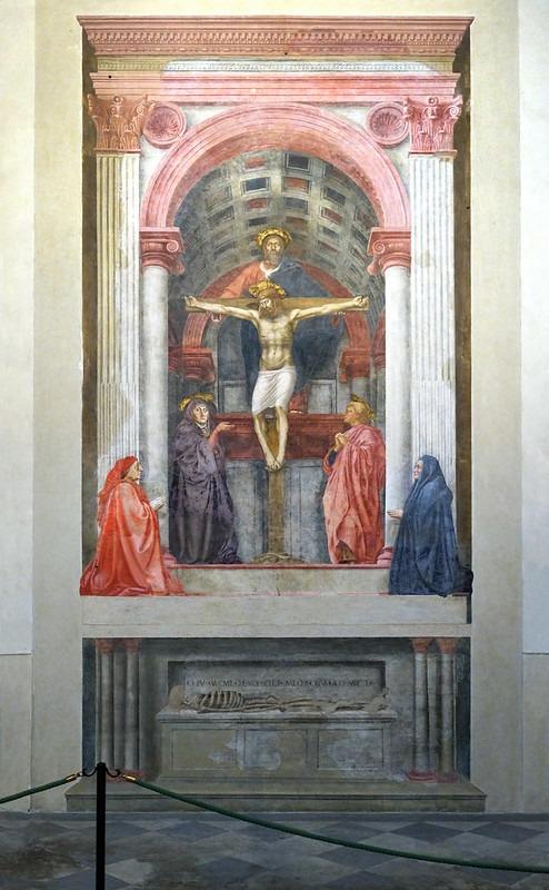 A fresco painting depicting the crucifixion of Jesus Christ with God the Father above and four mourners below, set within an architectural frame featuring columns and an arch. The artwork uses muted colors with red and blue robes on the figures and emphasizes religious solemnity and divine presence.