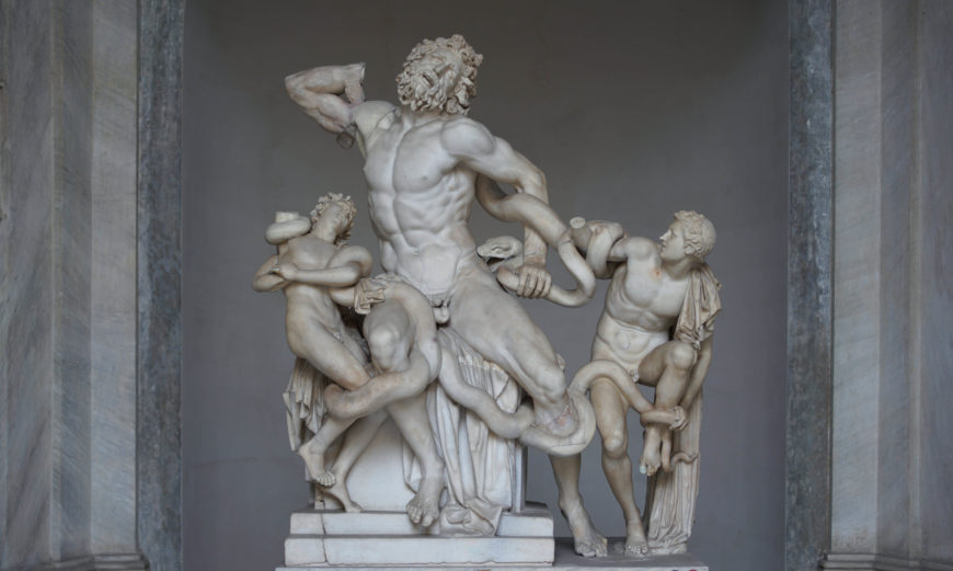 A photograph of the Laocoön and His Sons marble sculpture depicting three muscular male figures struggling with large serpents. The sculpture highlights intricate details of anatomy, expressions of pain and struggle, and dynamic composition within a niche setting.
