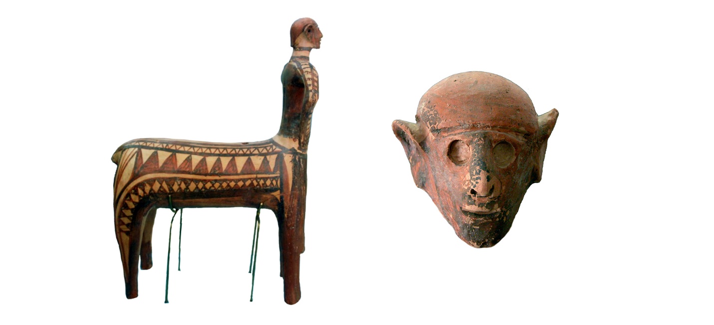 Photograph of two ancient terracotta sculptures displayed against a white background. One sculpture depicts a four-legged animal with a human-like head and geometric patterns on its body, while the other shows a rounded human head with prominent ears and a blurred facial area.