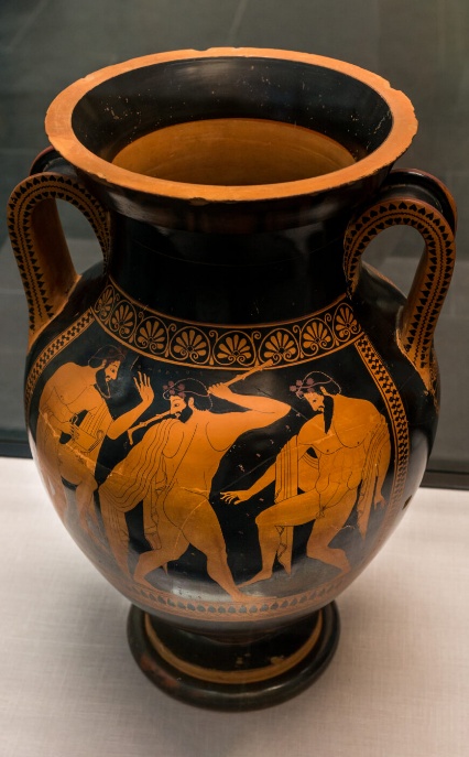 Photograph Euthymides, Three Revelers red-figure amphora depicting three male figures in dynamic poses. The vase features intricate floral patterns around the neck and handles, with detailed orange and black coloration highlighting muscles and garments.