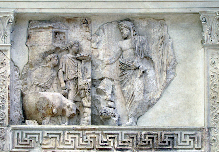 Bas-relief sculpture depicting a classical scene with three human figures and a bull, carved in white stone with intricate details. The composition includes a standing male figure draped in cloth, two other figures interacting with the bull, and a decorative geometric border along the bottom.