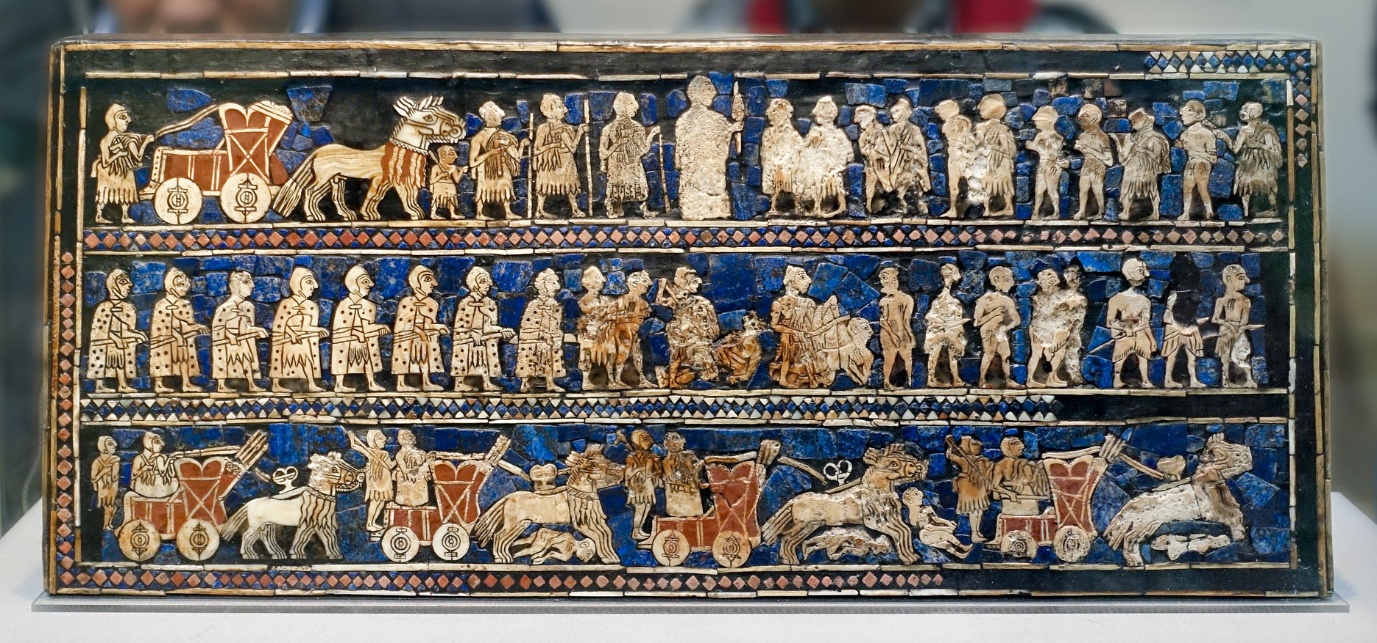Photograph of the War (detail) on Standard of Ur, an ancient Sumerian artifact featuring detailed inlaid mosaic panels depicting scenes of war and peace. The rectangular box shows three horizontal registers with figures of soldiers, chariots, animals, and attendants, highlighted by blue lapis lazuli background and intricate ivory and shell inlays.