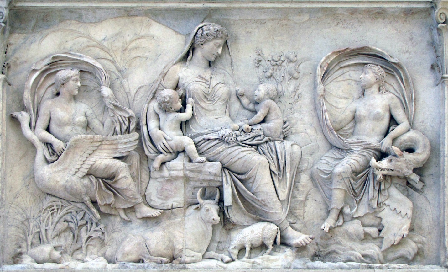 Bas-relief sculpture depicting a central seated female figure with two children, flanked by two winged figures, one on each side. The scene includes detailed elements such as animals, plants, and a geometric border pattern at the bottom, showcasing classical artistic style and mythological themes.