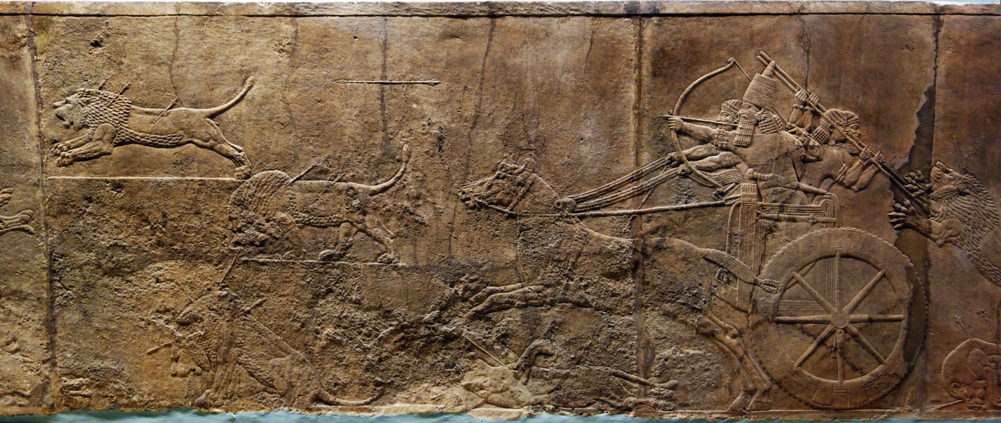 Lion Hunts of Ashurbanipal bas-relief carving depicting an ancient battle scene with a chariot drawn by horses on the right and a lion attacking on the left. The artwork features detailed figures of warriors, animals, and weapons, highlighting motion and conflict.
