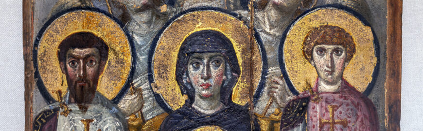 Detail of a religious icon featuring three saints with golden halos and detailed robes in blue, white, and purple. The artwork showcases intricate textures and metallic highlights on a wooden panel background.