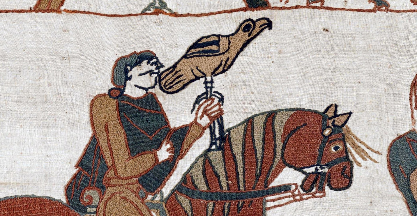 A detailed embroidery panel from the Bayeux Tapestry depicts a man holding a falcon while seated on a horse. The scene uses muted earth tones with intricate stitching to illustrate medieval falconry and horseback riding.