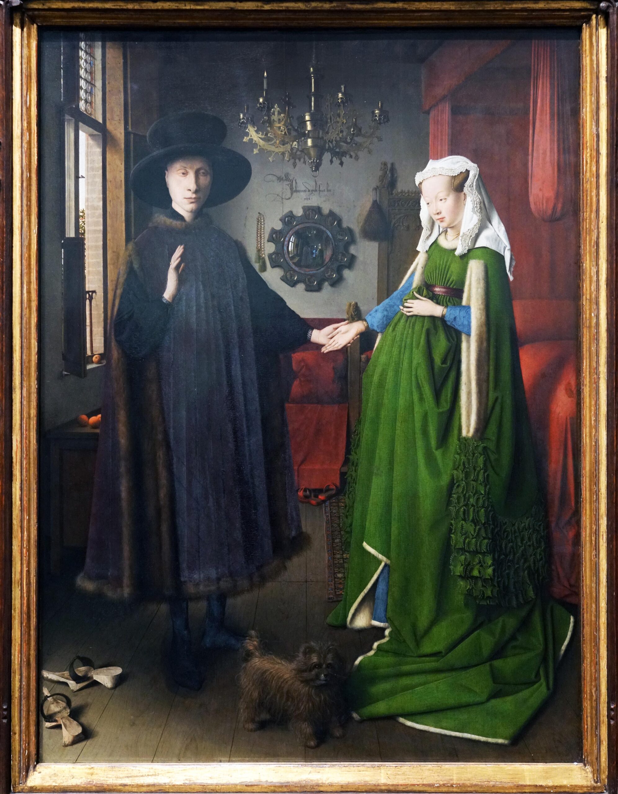 Jan van Eyck, The Arnolfini Portrait painting depicting a man and a woman holding hands in an interior room, with a small dog at their feet. The scene features detailed clothing, a chandelier, a mirror on the wall, and shoes on the floor, highlighting a moment of domestic life and connection.