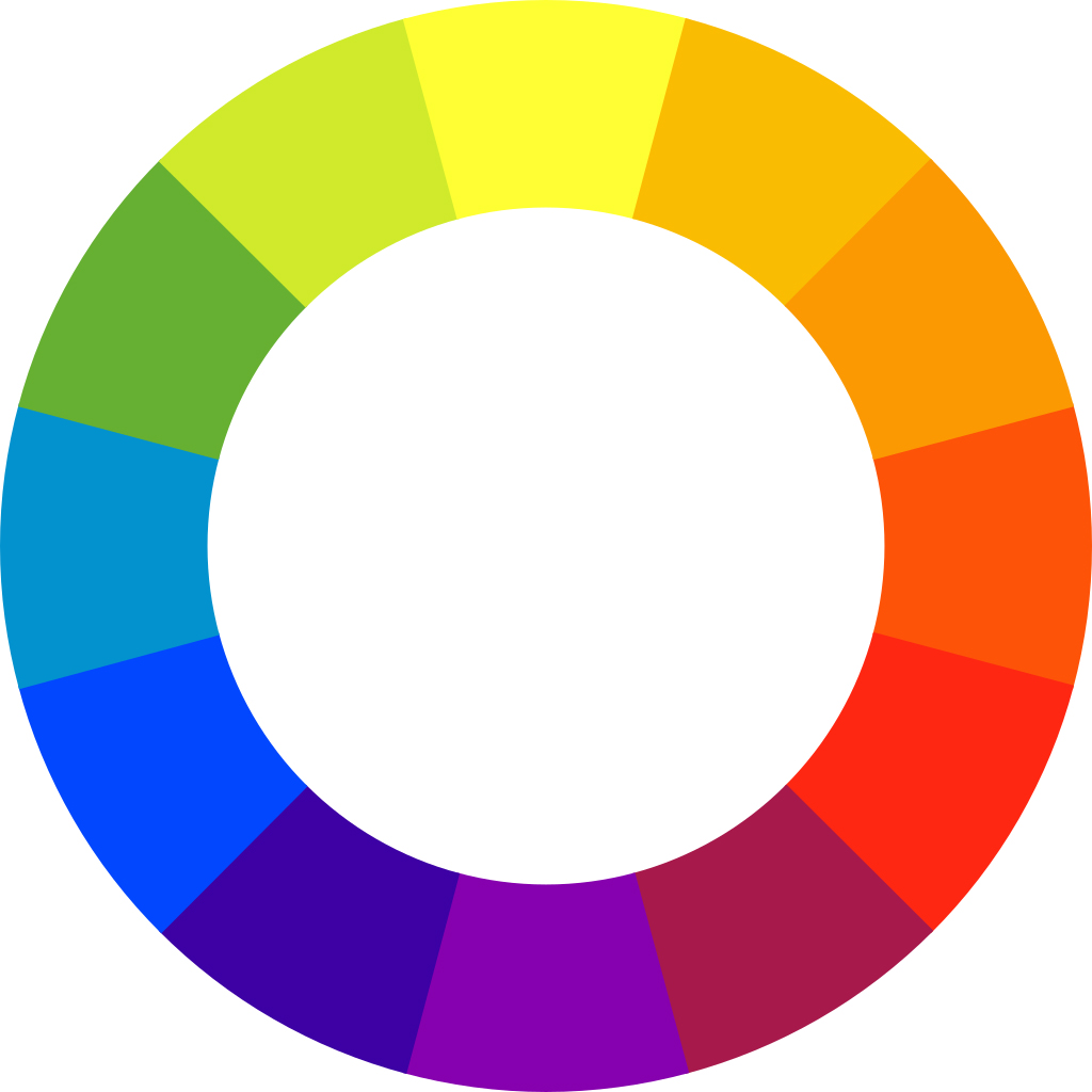 Color wheel diagram displaying a continuous spectrum of twelve colors arranged in a circular gradient from green to yellow, orange, red, purple, blue, and back to green. The wheel serves as a visual tool for understanding color relationships and harmonies, featuring evenly spaced color segments without labels or numerical data.