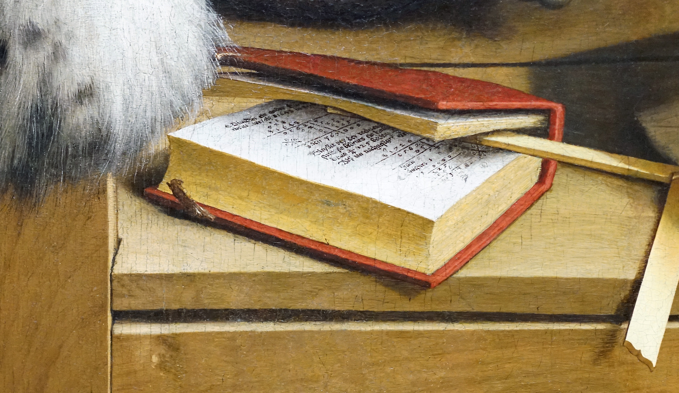 Detail from a painting featuring an open book with a red cover resting on a wooden surface, featuring handwritten text on visible pages. A wooden pointer lies across the book, and a fur garment is partially visible in the upper left corner, suggesting a historical or scholarly context.