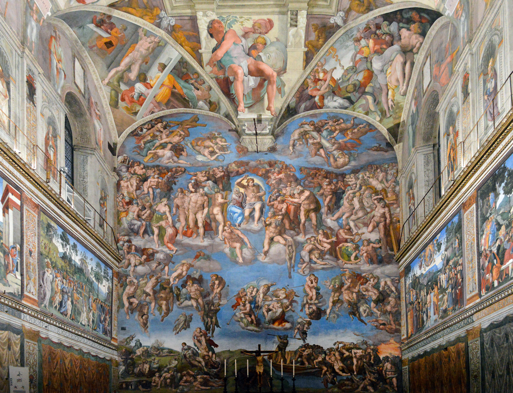 Michelangelo, Last Judgment, Sistine Chapel, altar wall fresco covering an entire chapel wall depicting numerous human figures in dynamic poses against a blue sky background. The artwork features detailed scenes of judgment and resurrection, with vibrant colors and intricate compositions framed by architectural elements and windows.