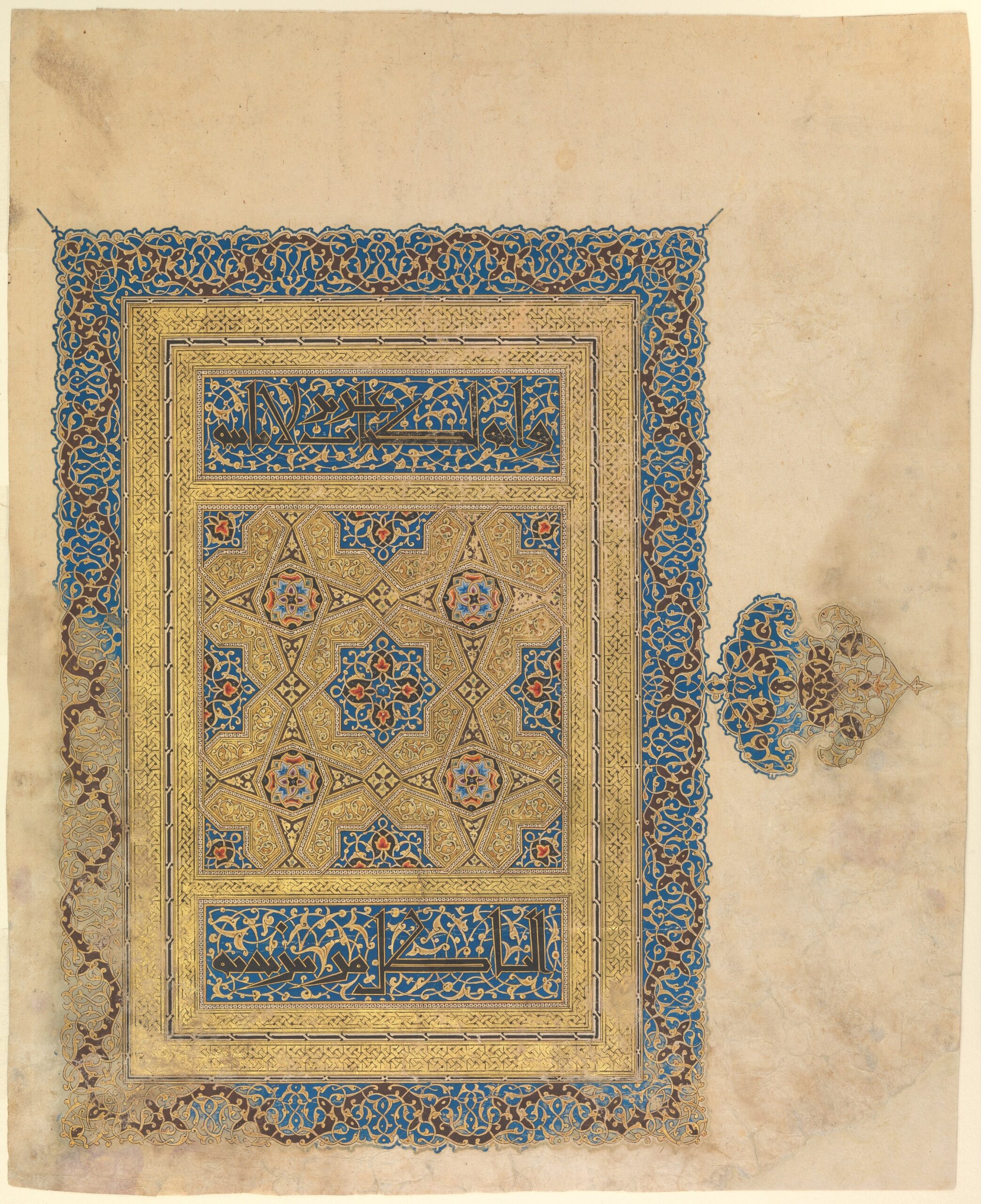 A photograph of an illuminated manuscript page featuring intricate geometric patterns and Arabic calligraphy. The design includes gold, blue, and red colors with a central star-shaped motif, bordered by detailed floral and vine patterns, showcasing traditional Islamic art elements.