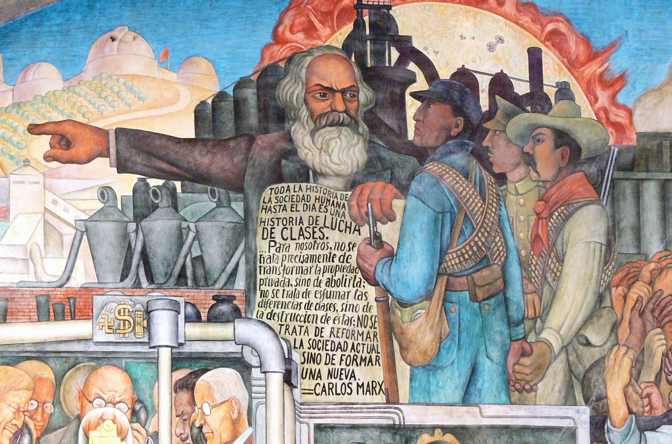 Mural painting depicting Karl Marx pointing forward while addressing workers and soldiers, symbolizing class struggle and social change. Background features industrial smokestacks, flames, and a factory setting, with a prominent text block in Spanish discussing history, class struggle, and societal transformation.