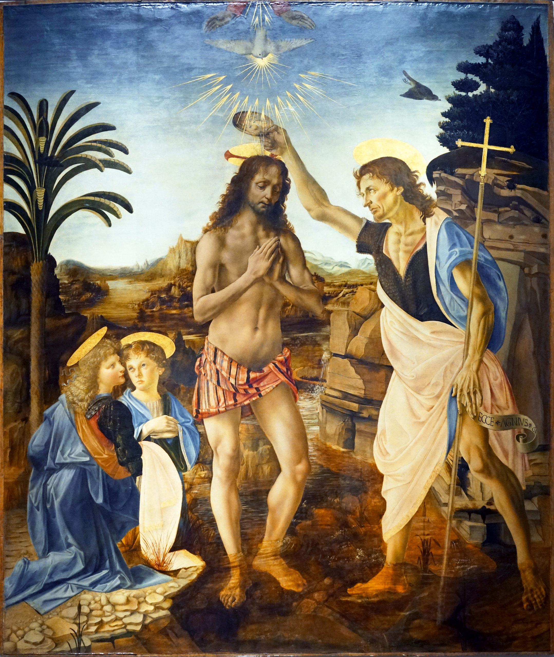A religious painting depicting the baptism of Jesus by John the Baptist in a natural landscape with a river and rocky terrain. Key elements include halos around figures' heads, a dove with radiant light above symbolizing the Holy Spirit, and two kneeling figures observing the scene.