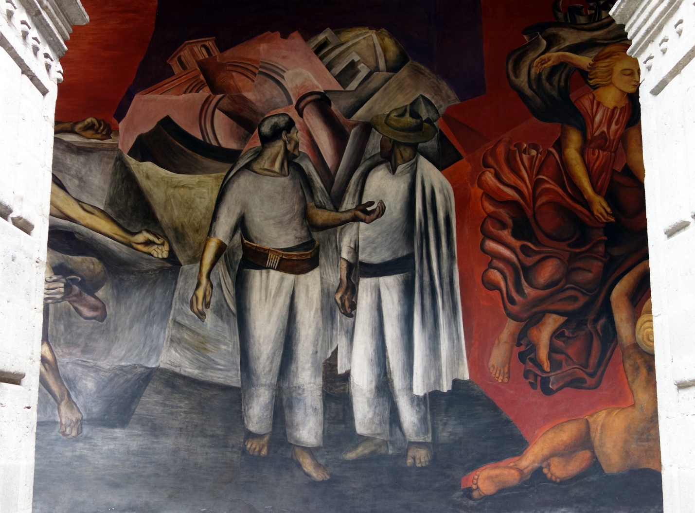A mural painting depicting two central figures in traditional clothing engaged in conversation, surrounded by abstract architectural shapes and flowing red fabric. The artwork uses muted earth tones and vibrant reds to contrast themes of culture, struggle, and movement.