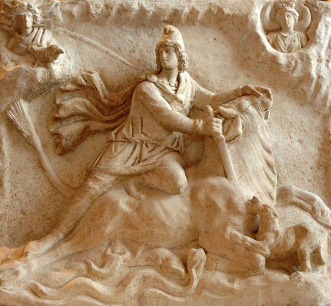 Stone carving of the god Mithras stabbing a bull.