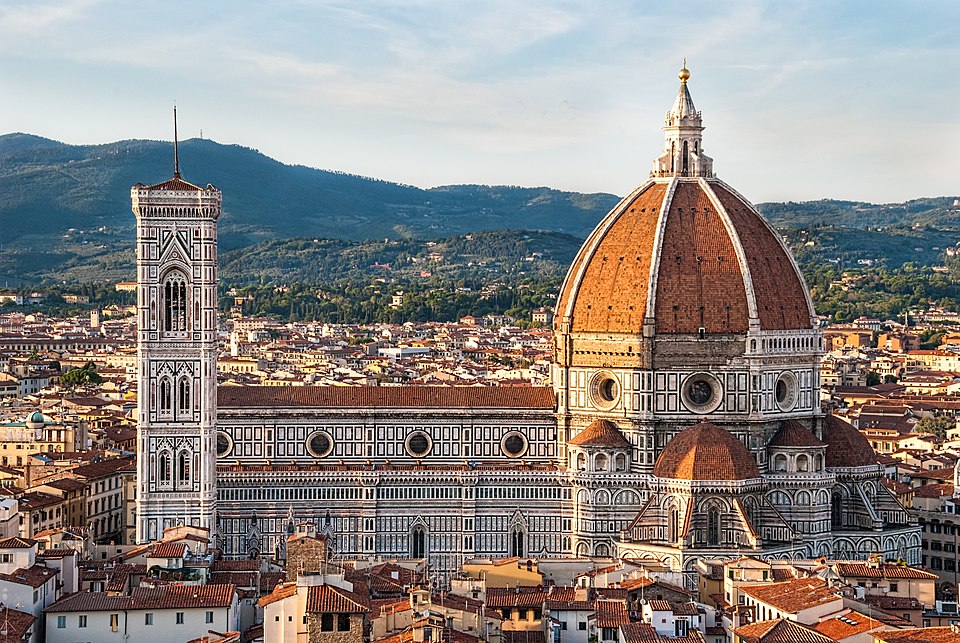 An exterior view of Florence Cathedral with mountains in the distance