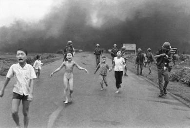 A group of Vietnamese children fleeing on a road as they escape an American napalm attack.